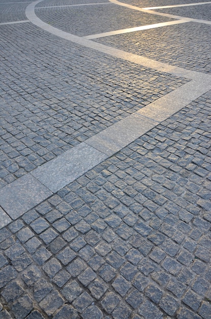 Frammento del quadrato della strada, piegato da una lastra di pietra quadrata grigia