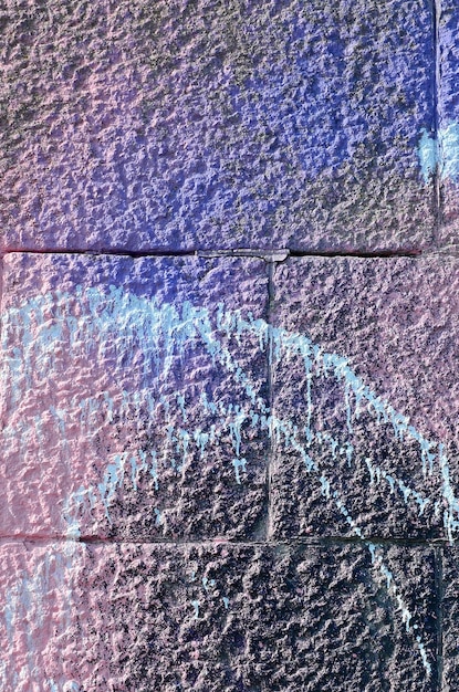 Frammento di disegni di graffiti Il vecchio muro decorato con macchie di vernice nello stile della cultura della street art Texture di sfondo colorata nei toni del viola