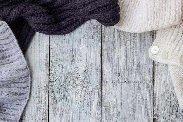 Frammento di tricottare i vestiti su fondo di legno bianco