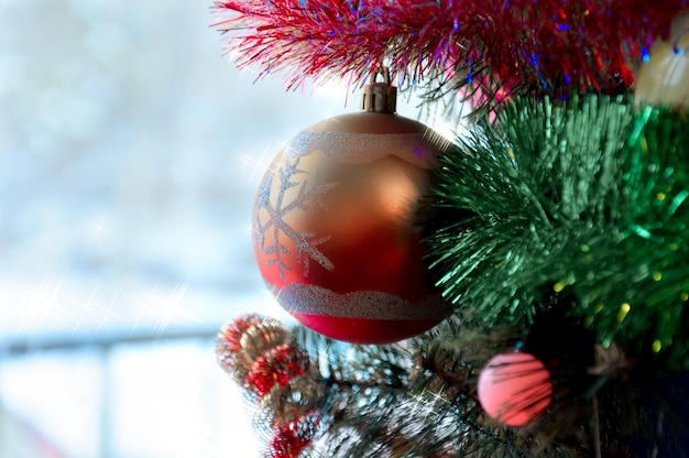 Frammento di un albero di Natale con giocattoli su sfondo invernale.