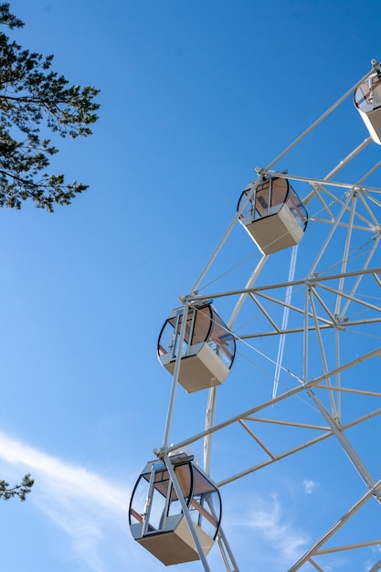 Frammento di una ruota panoramica su uno sfondo di cielo blu e nuvole