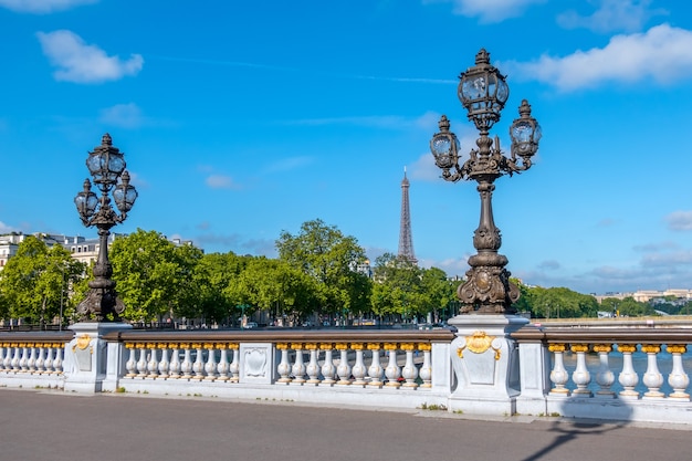 Francia, Parigi. Giornata di sole estivo. Lanterne sul ponte Alexandre III sul fiume Senna. Torre Eiffel in lontananza