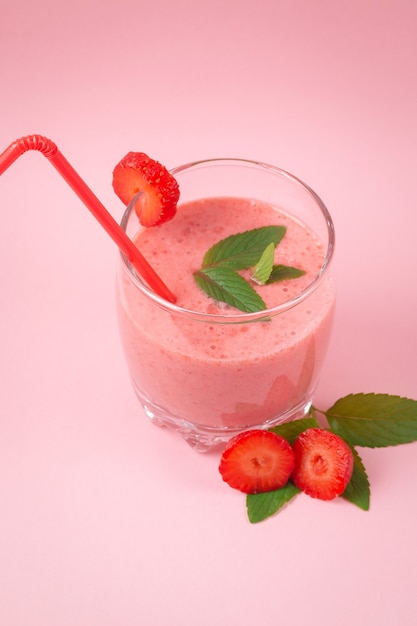 Frappè alla fragola con menta su una superficie rosa. Mangiare sano a colazione e a merenda