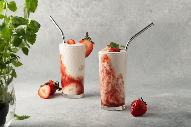 Frappè alla fragola in vetro su sfondo grigio