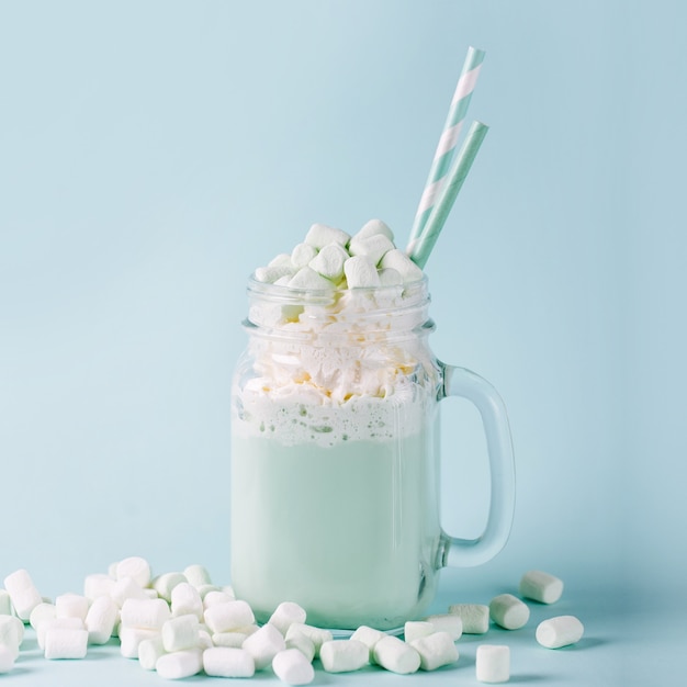 Frappè con Marshmallows in un barattolo di vetro su sfondo blu