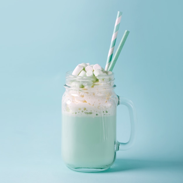 Frappè con Marshmallows in un barattolo di vetro su sfondo blu