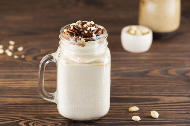 Frappè con noci e caramello in una tazza su un tavolo di legno Zucchero vegano e senza lattosio