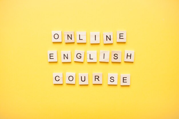 Frase corso di inglese online a base di blocchi di legno su un colore giallo chiaro