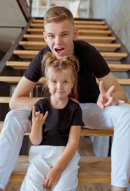 fratelli caucasici adolescente ragazzo fratello e bambina sorella seduti sulle scale in loft interior