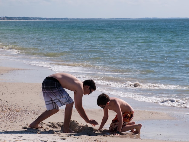 Fratelli che giocano nella sabbia sulla spiaggia del Messico, in Florida.