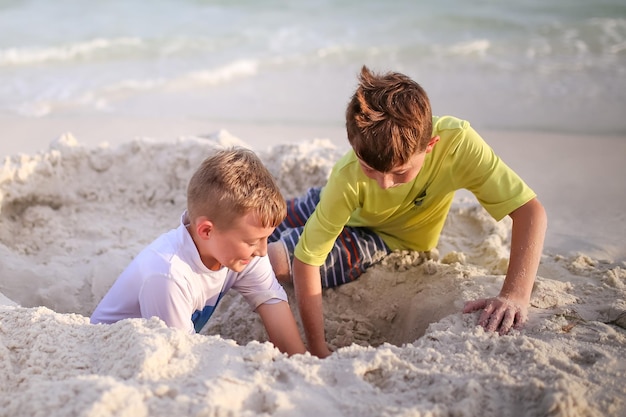 Fratelli che scavano una buca sulla spiaggia