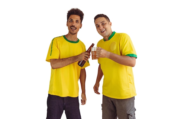 Fratelli neri con camicia brasiliana gialla e bottiglia di birra che incoraggiano isolati su bianco