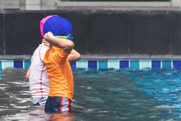 Fratello asiatico stanno giocando in piscina