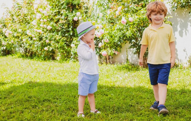 Fratello bambino sorridente a piedi Bambini all'aperto nel parco primaverile Bambini divertenti