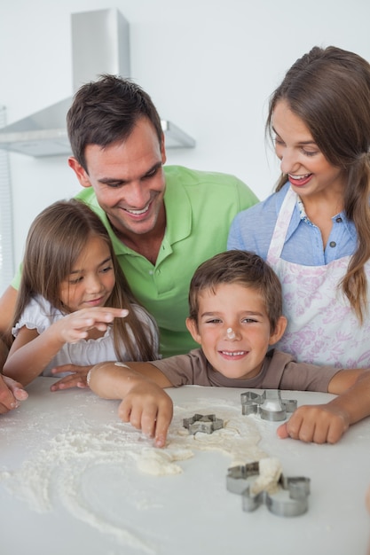 Fratello con farina sul naso in cottura con la sua famiglia