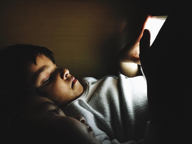 Fratello con sorella che usano un tablet digitale mentre si rilassano a casa