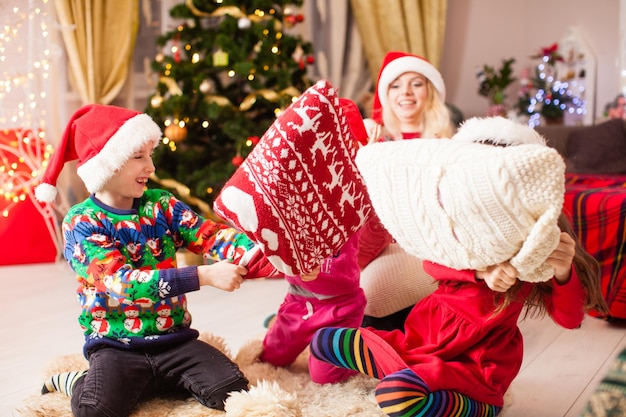 Fratello e sorella alla festa serale di Chrismtas, i bambini si tengono per mano il cuscino da battaglia, l'ora del pavimento