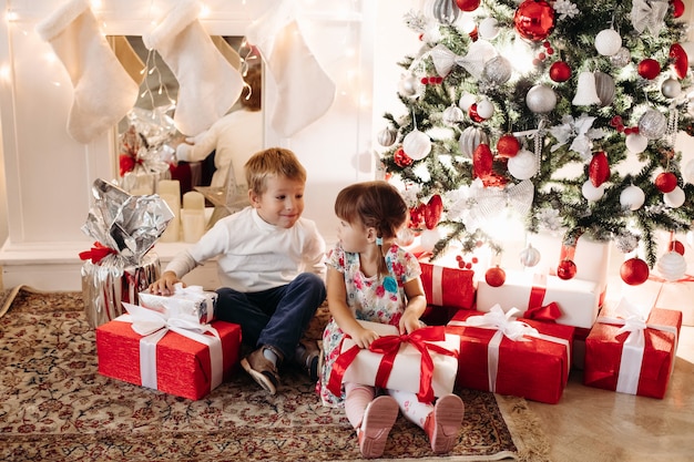 Fratello e sorella che aprono i regali di Natale