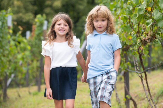 Fratello e sorella che camminano all'aperto Ragazzino e ragazza che lavorano in giardino Due bambini felici nel parco estivo Concetto di vacanza estiva per bambini Amicizia dei bambini