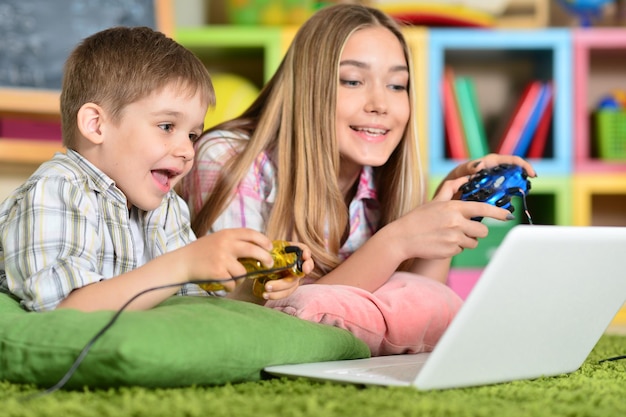 Fratello e sorella che giocano al computer sul laptop