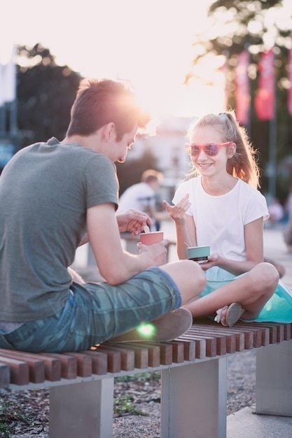Fratello e sorella che mangiano il gelato mentre sono in città