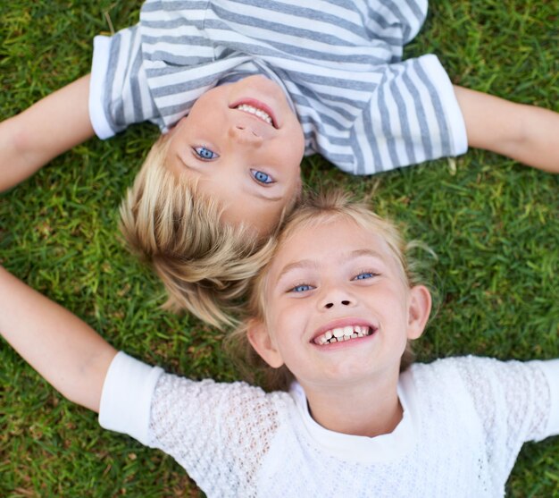 Fratello e sorella che si legano Fratello e sorella che si rilassano sull'erba nel cortile