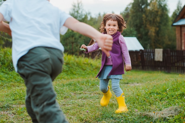 Fratello e sorella corrono nella casa del villaggio. vacanze al villaggio con mia nonna.