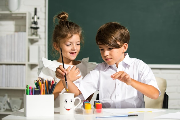 Fratello e sorella di bambini che disegnano un simpatico disegno usando matite colorate a scuola o all'asilo