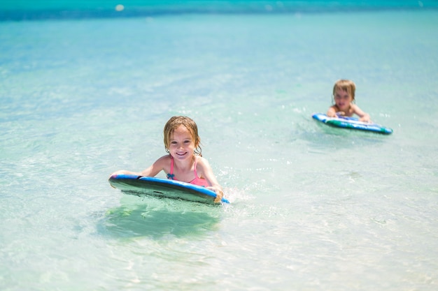 Fratello e sorella gemelli per divertirsi con il surf nell'oceano