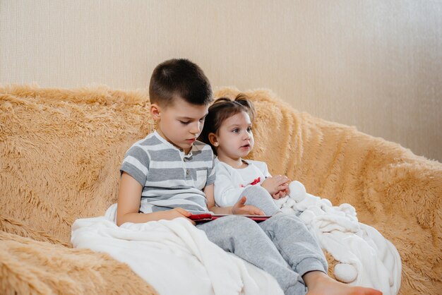 Fratello e sorella giocano sul divano del tablet