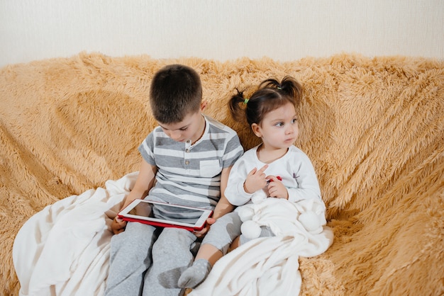 Fratello e sorella giocano sul divano del tablet