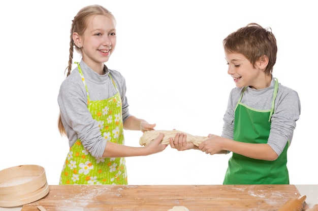 fratello e sorella preparano l'impasto per la cottura divertendosi su sfondo bianco