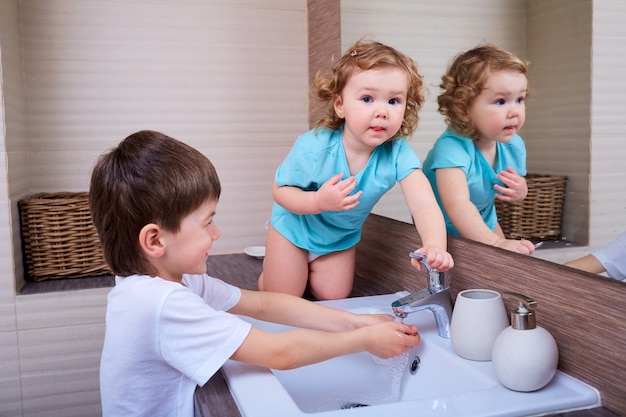 Fratello e sorella si divertono nella vasca da bagno igiene salute famiglia