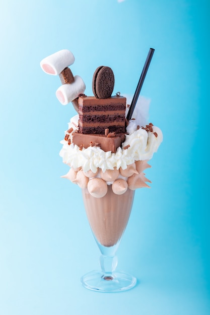 Freakshake al latte al cioccolato con panna montata, marshmallow, torta, biscotto