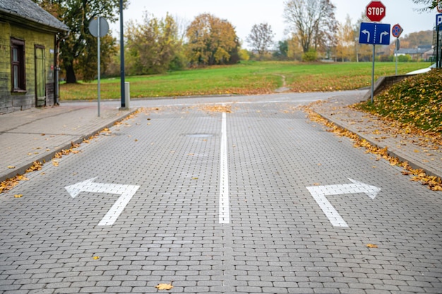 Frecce di direzione su strada asfaltata al concetto di scelta dell'intersezione