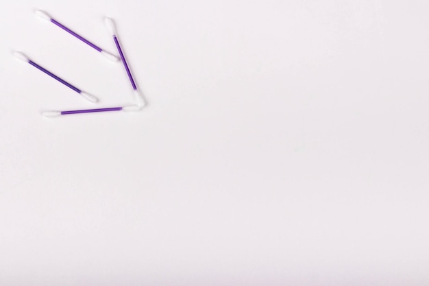 Freccia di bastoncini di cotone viola su sfondo bianco copia spazio