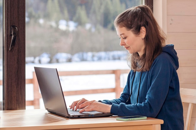 Freelancer Donna che lavora a distanza online con laptop, Smart Phone in Winter Snow Mountains.