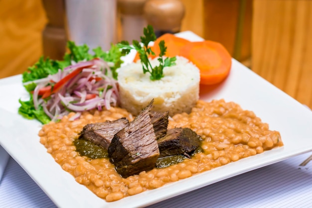 Frejoles con seco stufato di fagioli con carne e riso cibo da ristorante gourmet peruviano