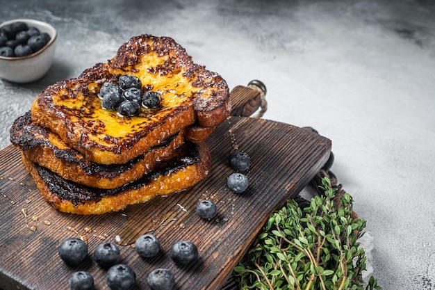 French Toast ai mirtilli con miele su tavola di legno. Sfondo bianco. Vista dall'alto. Copia spazio.