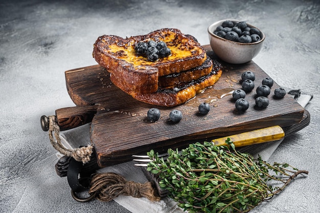 French Toast ai mirtilli con miele su tavola di legno Sfondo bianco Vista dall'alto