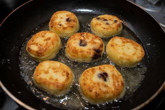 Fresche e gustose frittelle di formaggio le cheesecake sono fritte in padella cibo tradizionale ucraino