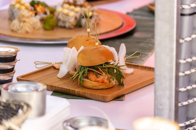 Freschi deliziosi hamburger alla griglia su tavola di legno Festival del cibo di strada