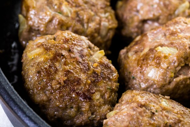 Friggere grandi polpette italiane fatte in casa su una padella media per cena.