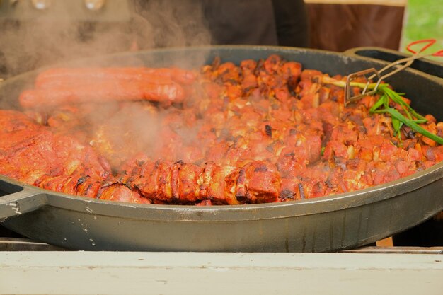 Friggere la carne in un grande calderone di ghisa