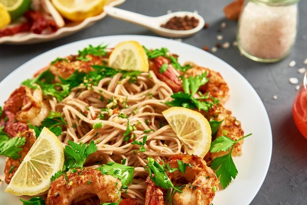 Friggere la pasta con gamberetti limone e prezzemolo fresco su piatto bianco soba con gamberi cucina asiatica vista dall'alto