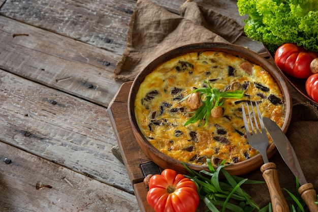 fritata o quiche con funghi di agarico e teglia per formaggi