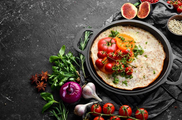 Frittata con pomodori e prezzemolo in padella Cibo per colazione Spazio libero per il testo Vista dall'alto