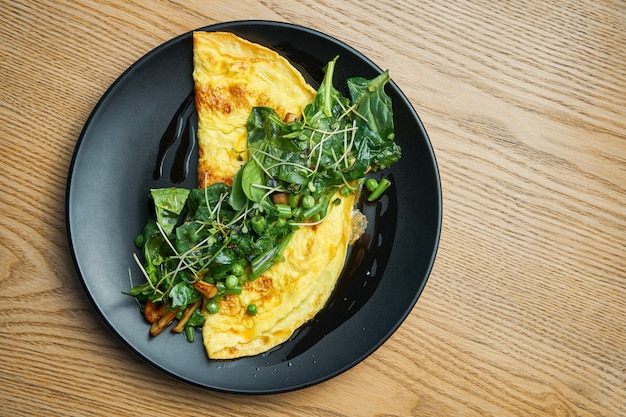 Frittata con salsa di pesto di funghi, rucola e piselli sulla banda nera. Pranzo gustoso e salutare. Frittata