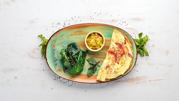 Frittata con spinaci e pomodori Colazione su sfondo di legno Spazio per la copia gratuito Vista dall'alto