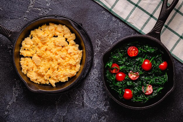 Frittata cotta e spinaci con pomodori in padelle vista dall'alto